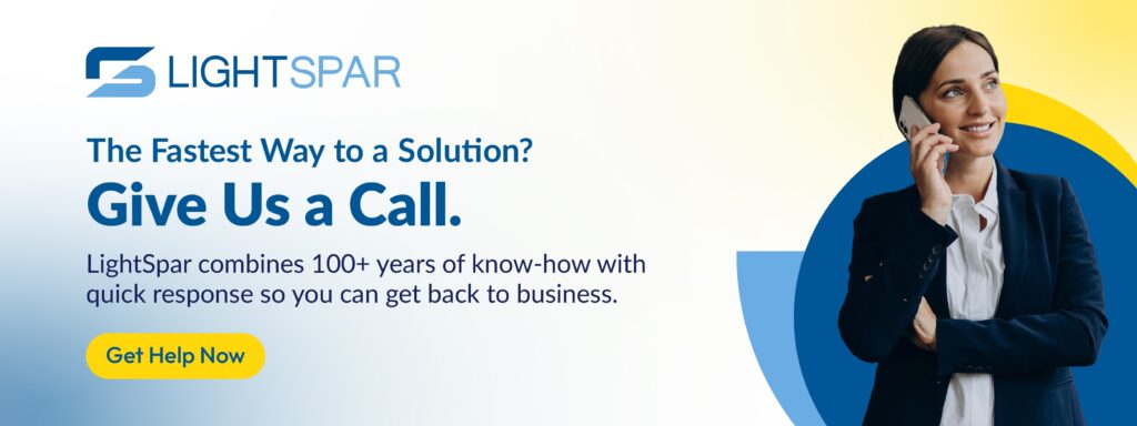 A professional woman smiles while talking on her mobile phone. Text promotes LightSpar’s quick-response services powered by business VoIP solutions, with a call-to-action button reading “Get Help Now.”
