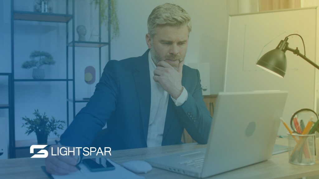 Person at desk searching on laptop. Conveys business owners searching about hosted VoIP.